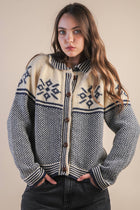 Woman wearing a patterned sweater against a plain background