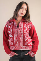 Woman wearing a red and white patterned sweater against a beige background