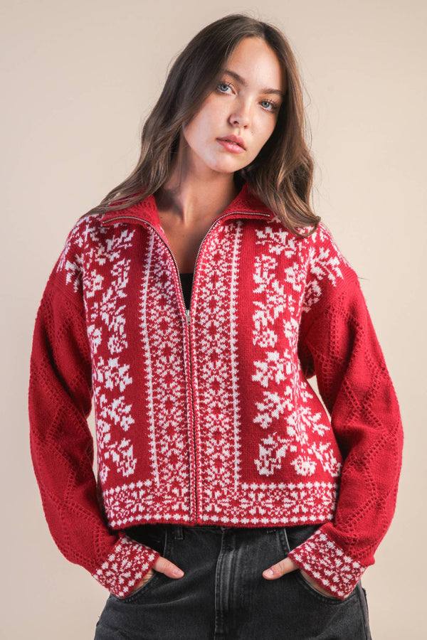 Woman wearing a red and white patterned sweater against a beige background