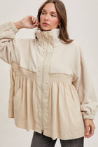 Woman wearing a beige puffer jacket on a plain background