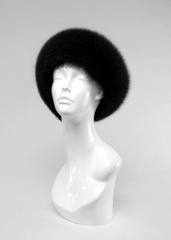 Black fur hat on a mannequin head against a gray background