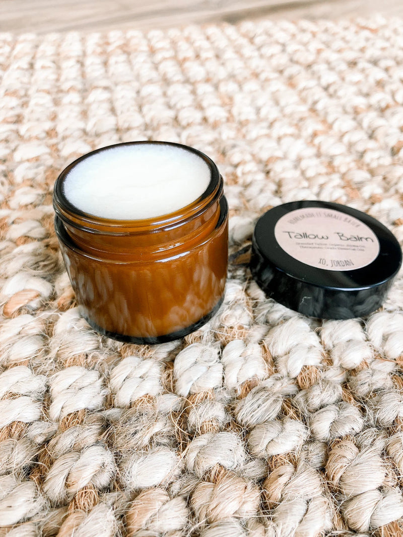 Brown jar with white cream on a textured beige surface