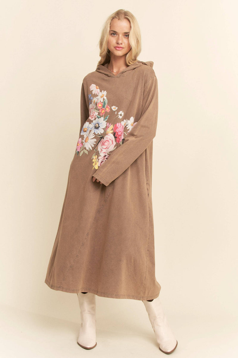 Woman wearing a brown hoodie dress with floral designs on a beige background