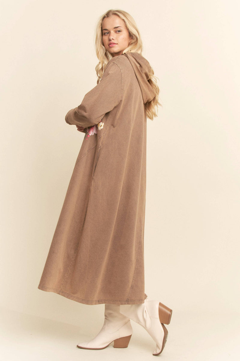 Woman wearing a long brown coat on a beige background