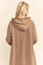Brown hooded coat worn by a person on a beige background