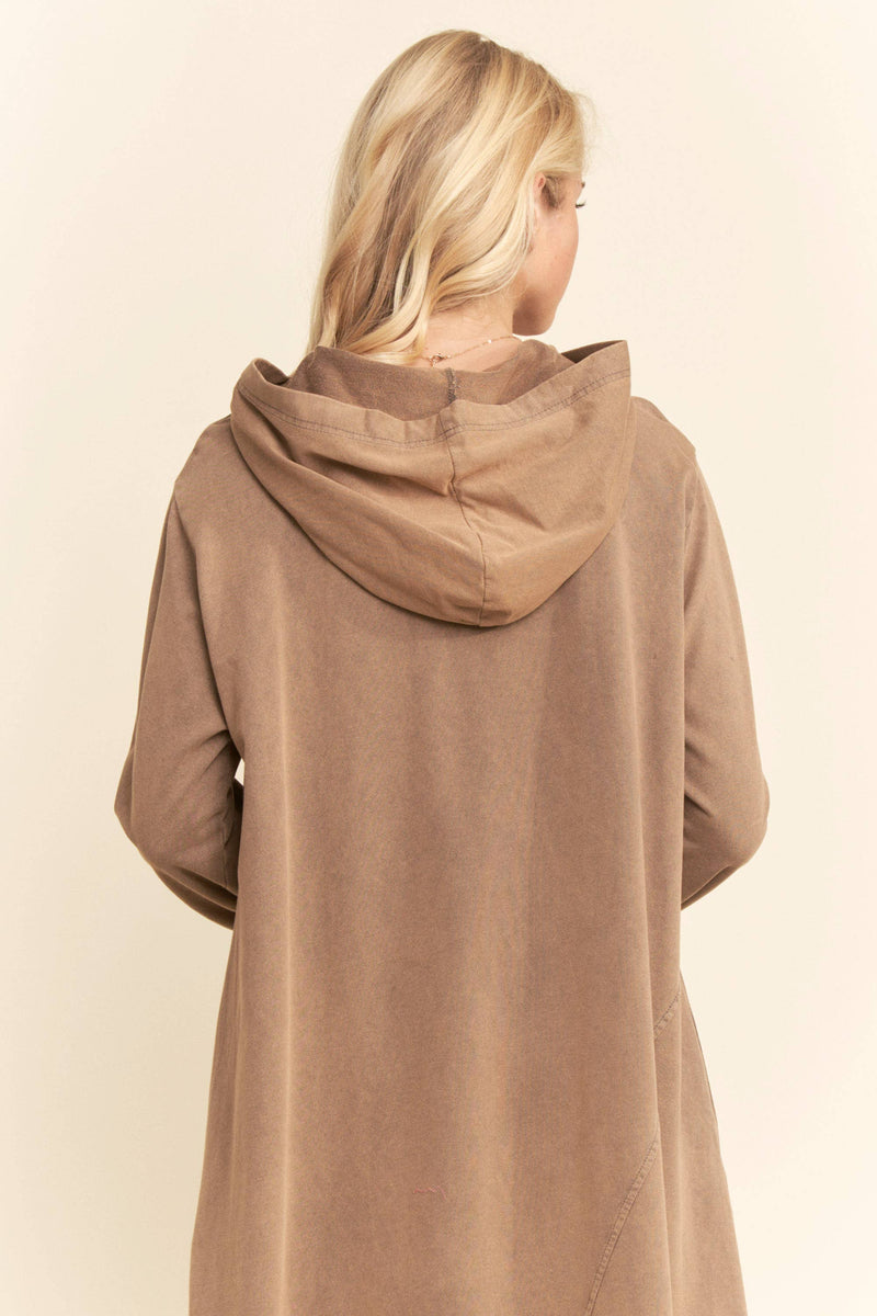 Brown hooded coat worn by a person on a beige background